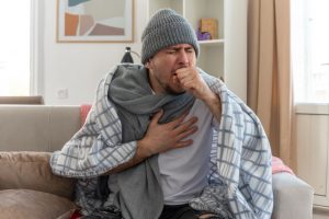 Hombre con tos y varios síntomas de la gripe
